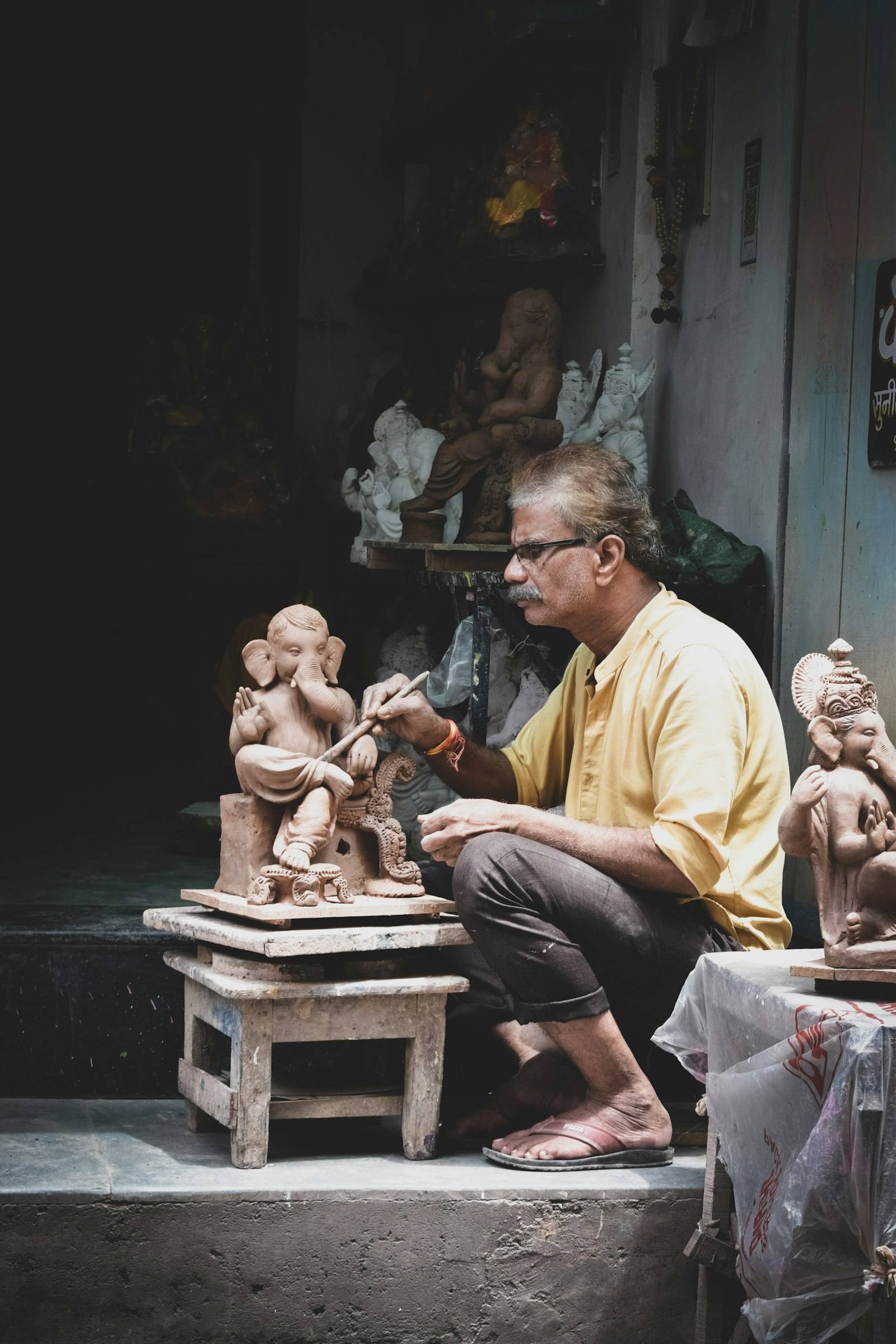 Artisan sculpting deity figures in his workshop