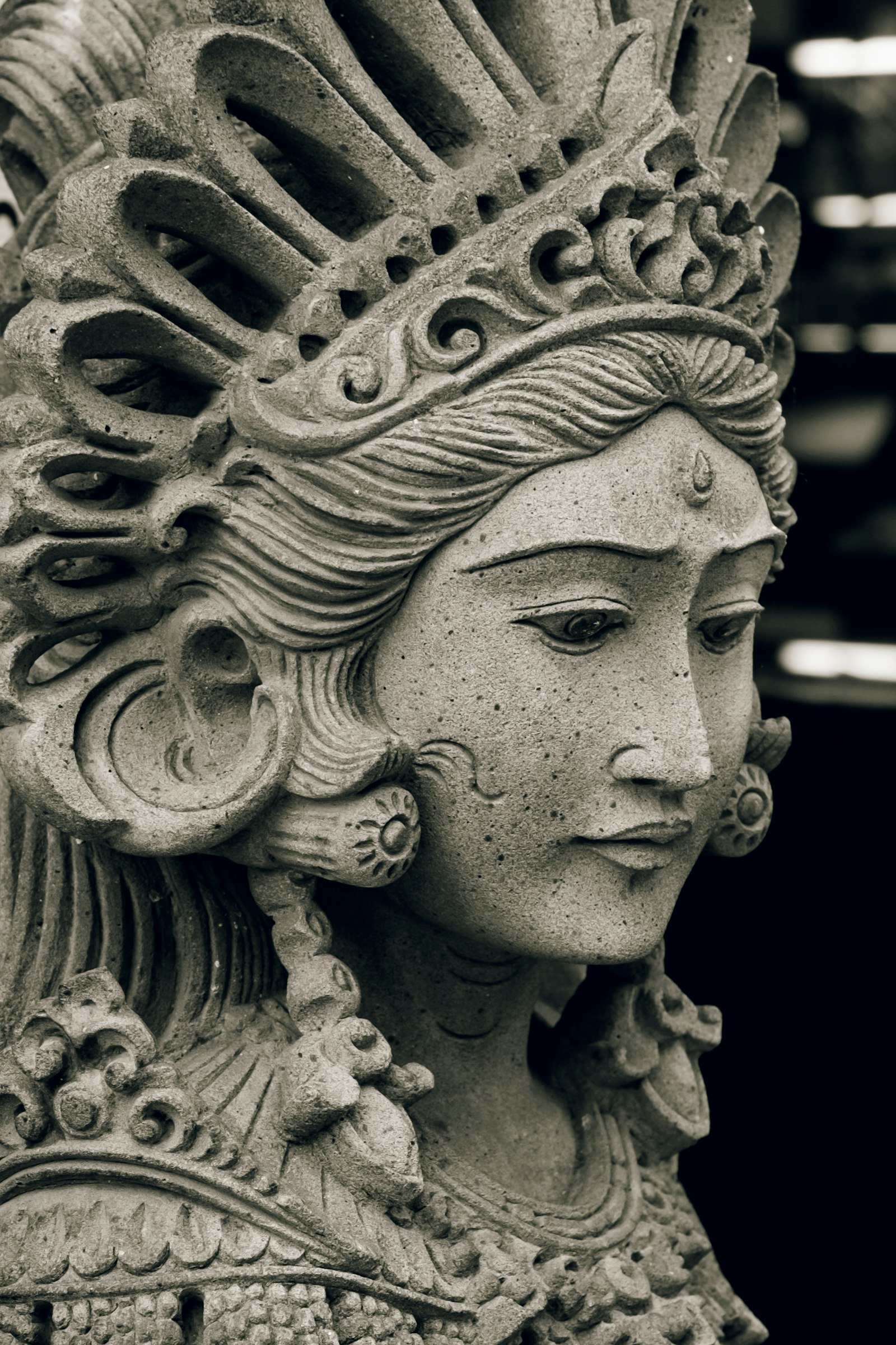Carved stone deity statuette with crown, classical style