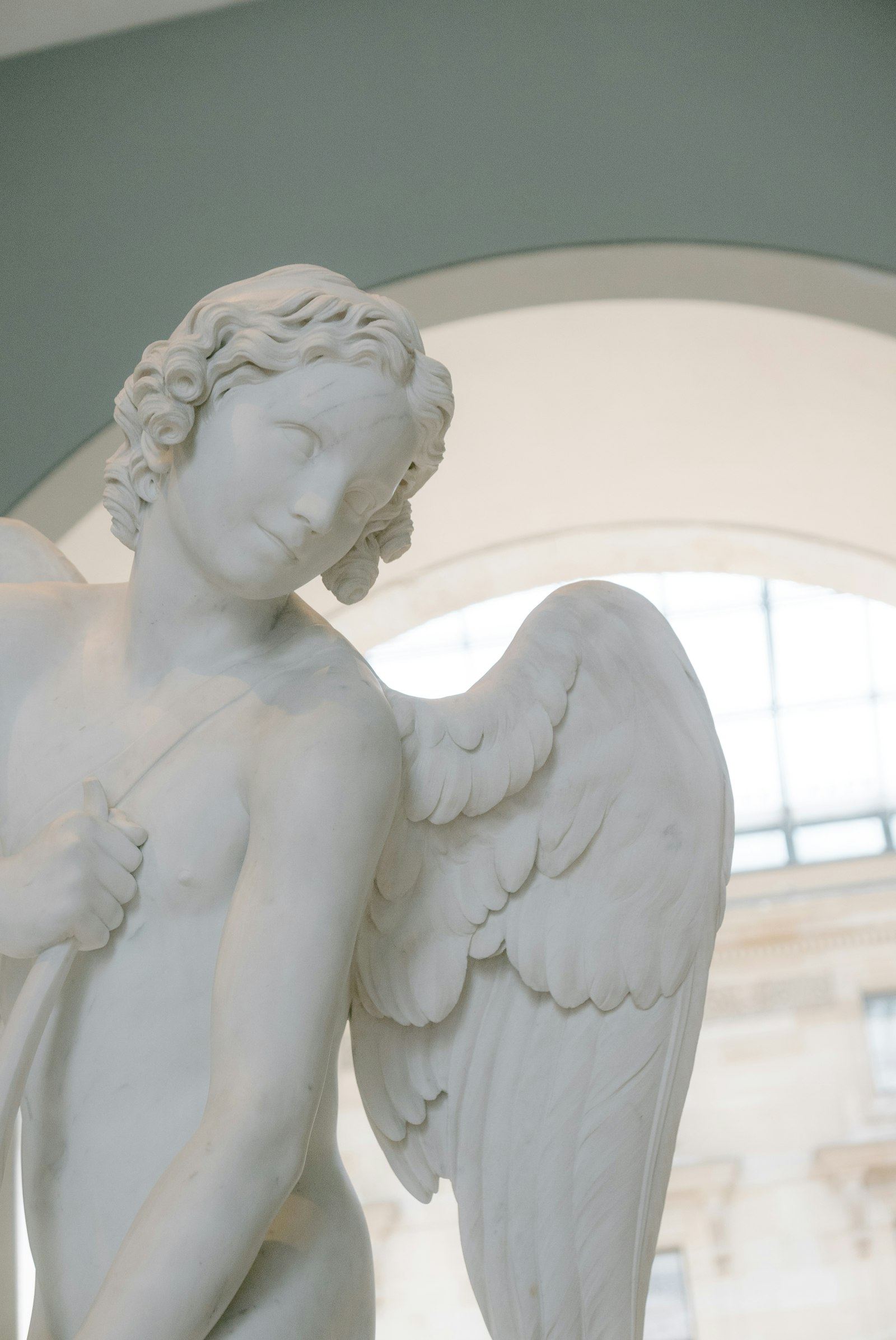 White marble angel statue in soft window light