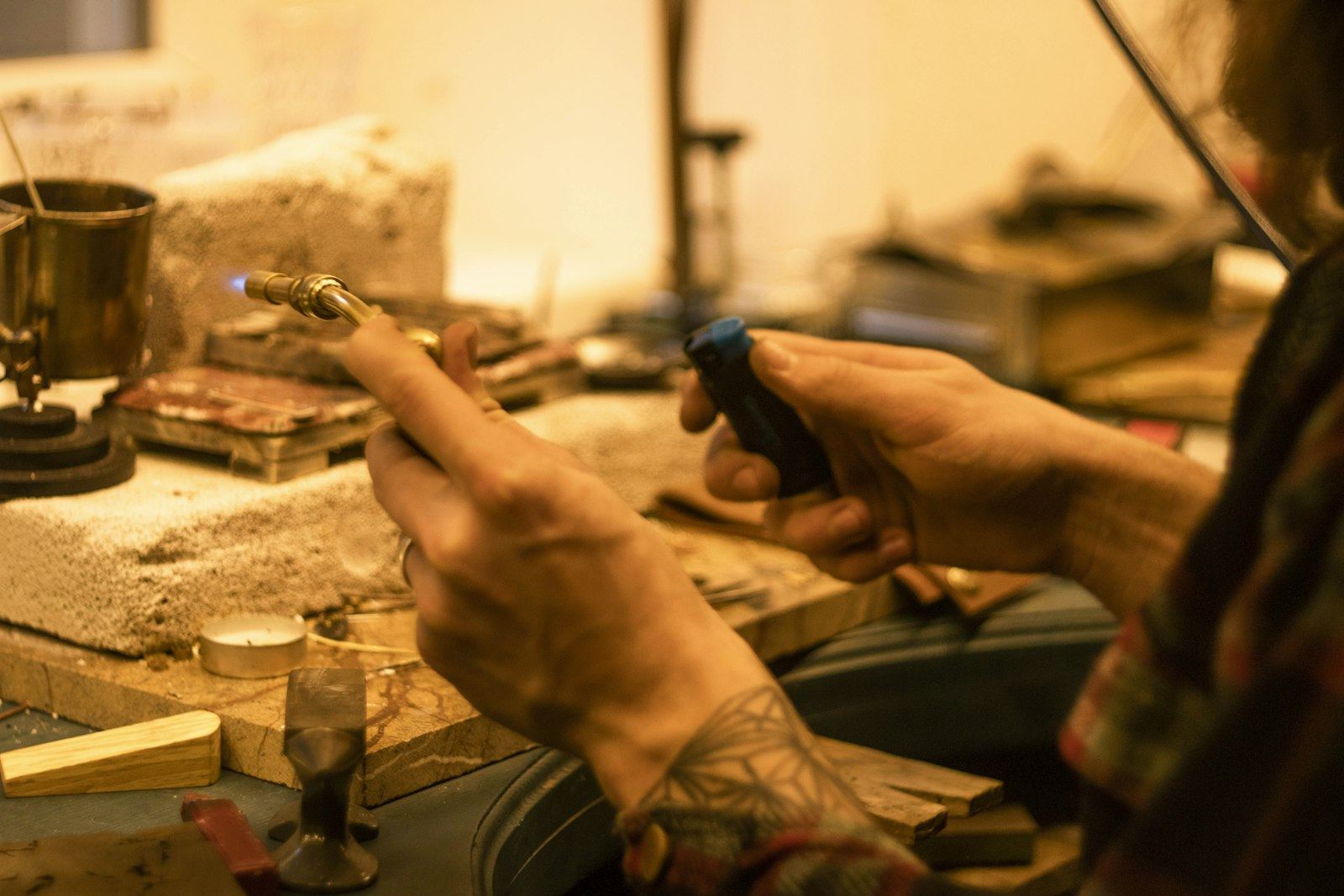 Craftsman hand-finishing metalwork at a workbench