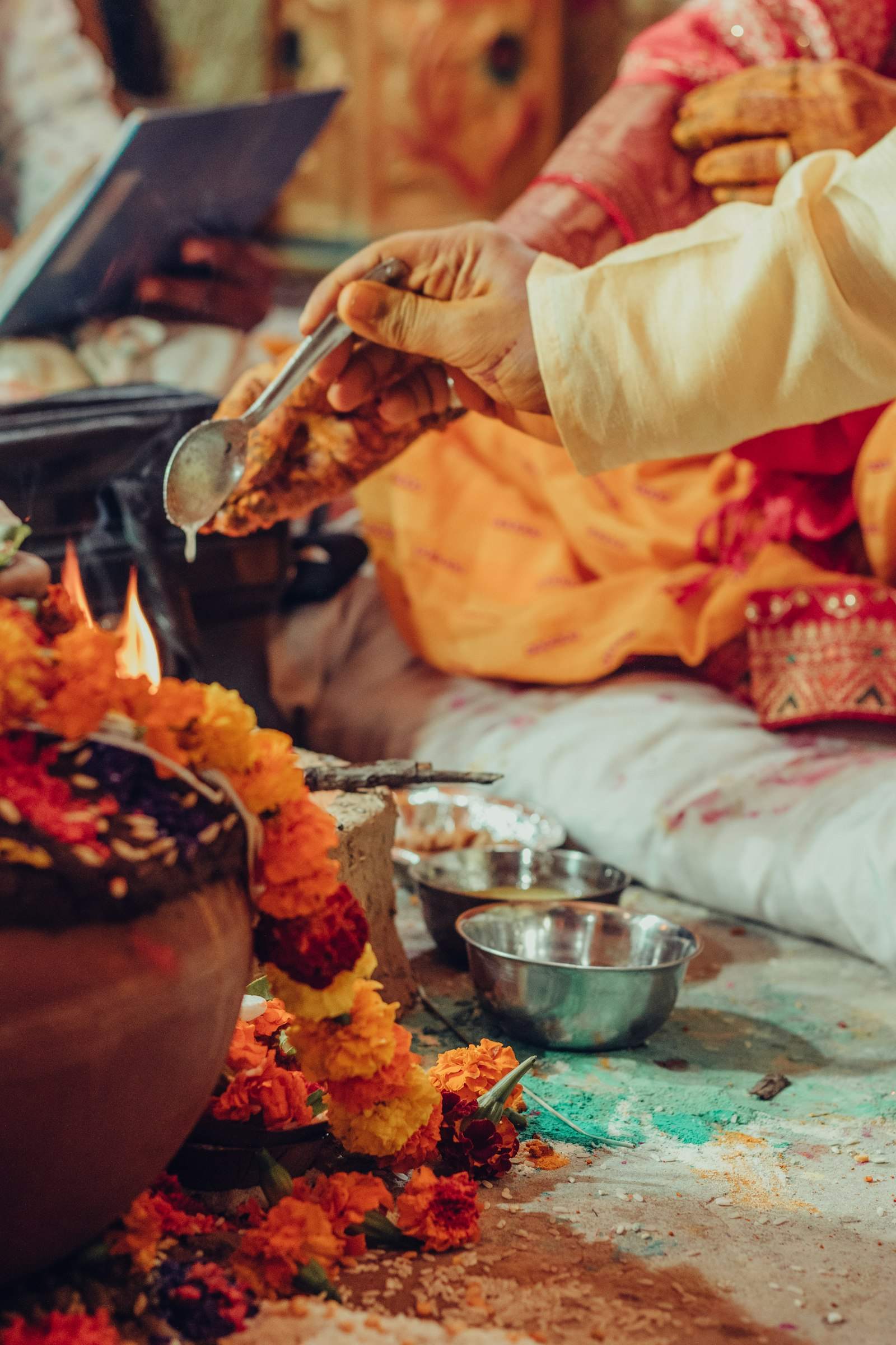 Hands making offerings with marigolds during a temple ritual